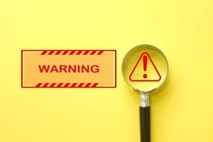 危険のマークと虫眼鏡