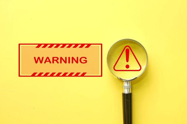 危険のマークと虫眼鏡