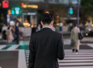 横断歩道を渡ろうとする男性の後ろ姿